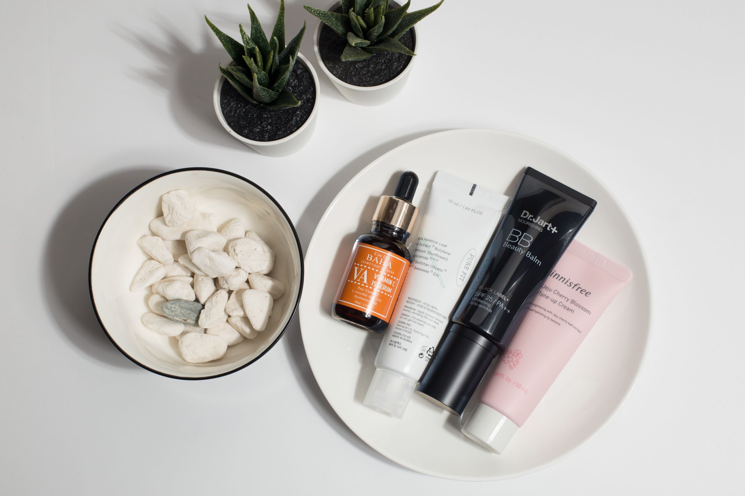 Korean skincare products and beauty creams arranged on a white plate