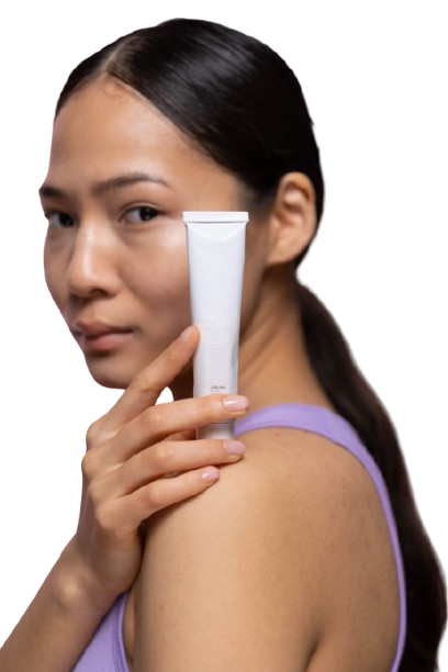 Woman holding a skincare cream tube near her face